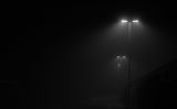 une rue le soir par temps de brouillard